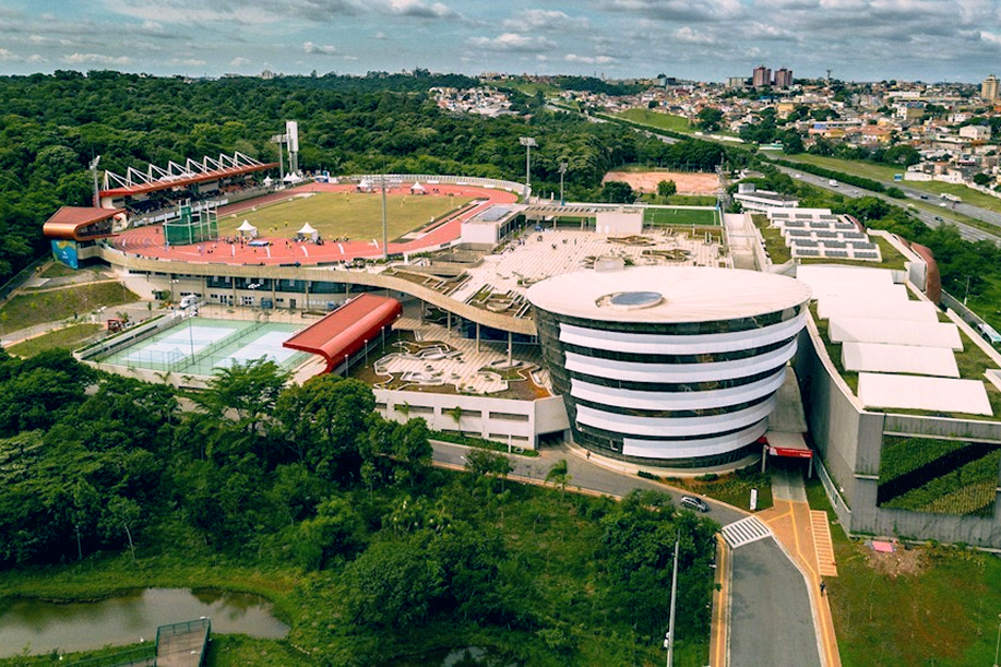 Visão panorâmica do complexo esportivo, destacando a pista de atletismo, áreas esportivas e a integração com o Parque Estadual Fontes do Ipiranga.