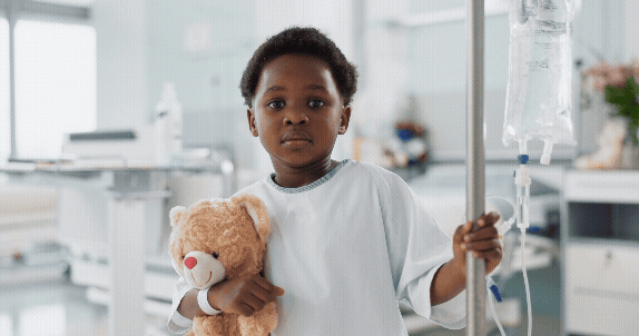 Vídeo curto decorativo animado, sem som e repetitivo, de uma criança preta doente no hospital, está segurando um ursinho de pelúcia, internada para cuidados de saúde com tratamento com soro intravenoso.