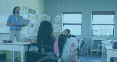 Vídeo curto decorativo animado, sem som e repetitivo, de uma sala multisseriada, com uma professora em pé explicando no quadro negro, com duas alunas assistindo, sendo que uma está sentada em uma cadeira de rodas. Todas usam máscaras. Sobre o vídeo, aparecem emojis de carinhas doentes e usando máscaras passando.