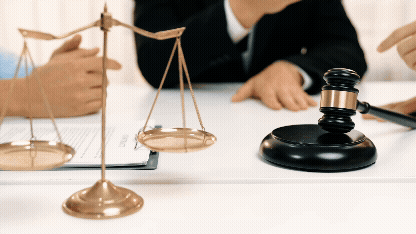 Vídeo curto decorativo animado, sem som e repetitivo, de 4 pessoas conversando ao redor de uma mesa, na qual podemos observar um martelo de juiz e uma balança de justiça, simbolizando as legislações.