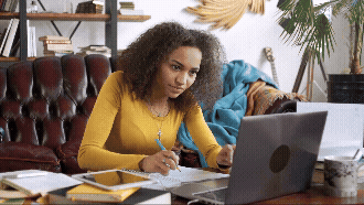 Vídeo curto decorativo animado, sem som e repetitivo, de uma professora preta estudando, sentada em frente ao notebook, fazendo anotações em um caderno, lendo um livro e utilizando marca texto.
